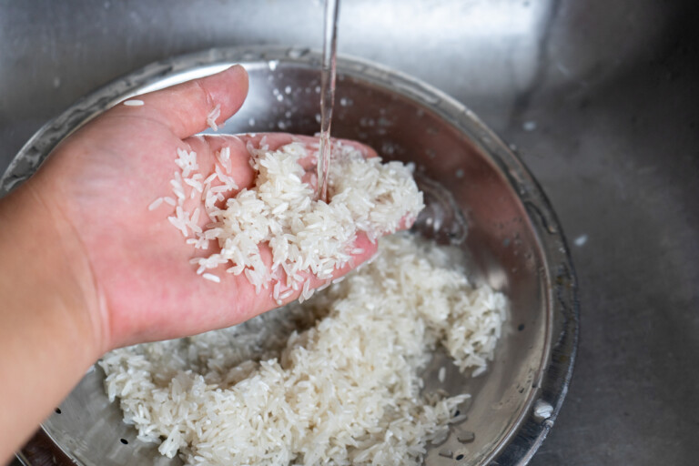 Washing white rice in metallic bowl