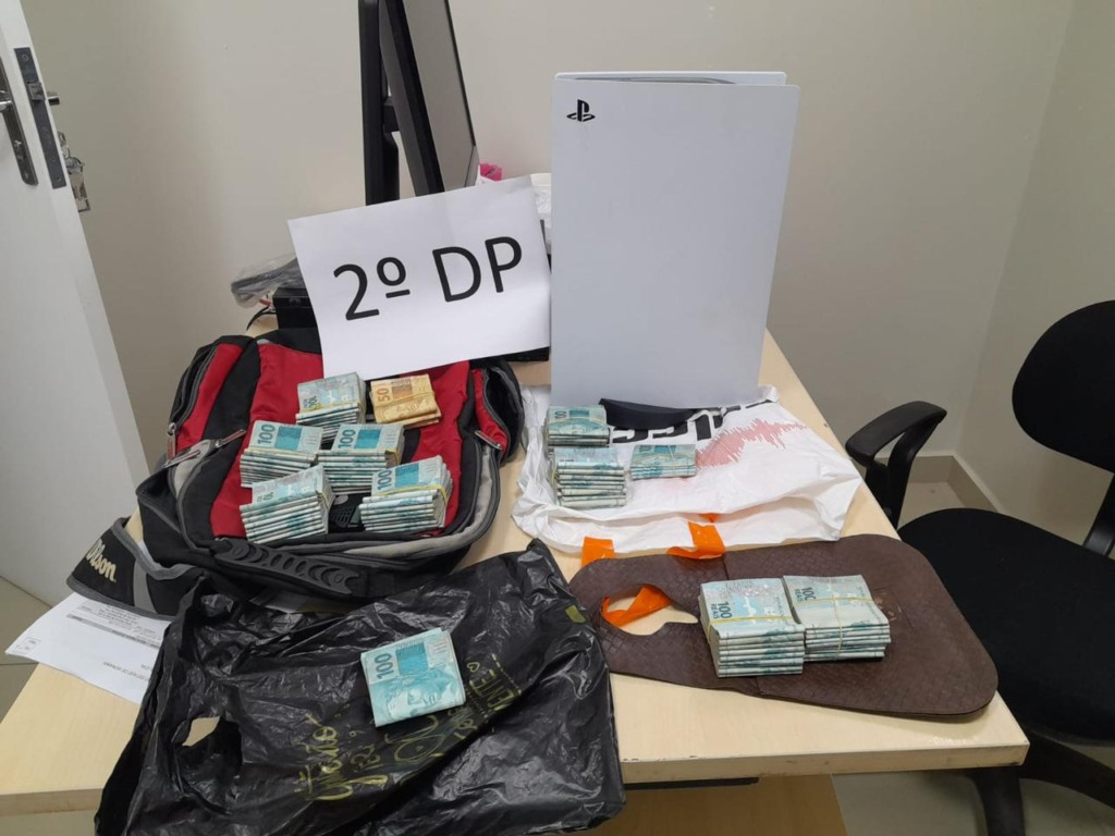Durante a investigação, os policiais encontraram com os suspeitos a importância de R$ 97 mil, celulares e um PlayStation, subtraídos das quatro vítimas. (Foto: reprodução/PCRR) Durante a investigação, os policiais encontraram com os suspeitos a importância de R$ 97 mil, celulares e um PlayStation, subtraídos das quatro vítimas. (Foto: reprodução/PCRR)