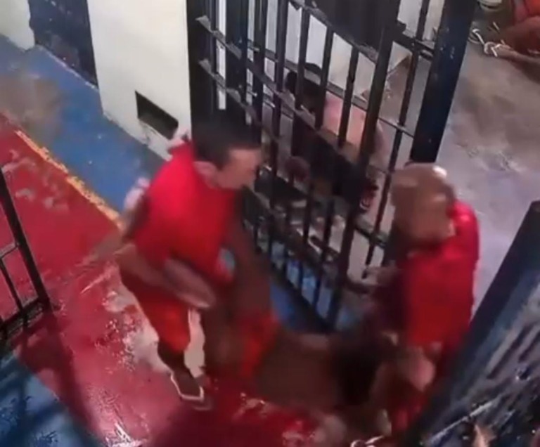 Dois detentos carregam um preso desfalecido (Foto: Reprodução)