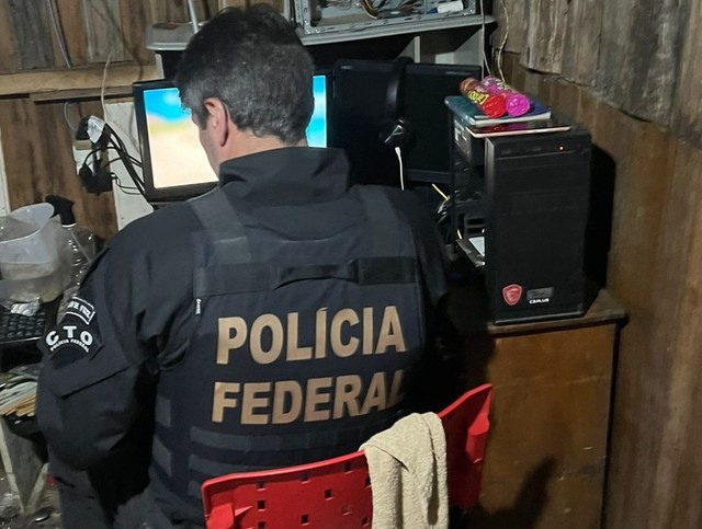 Momento em que a Polícia Federal procura conteúdos pornográficos na residência de um dos suspeitos (Foto: Ascom PF)