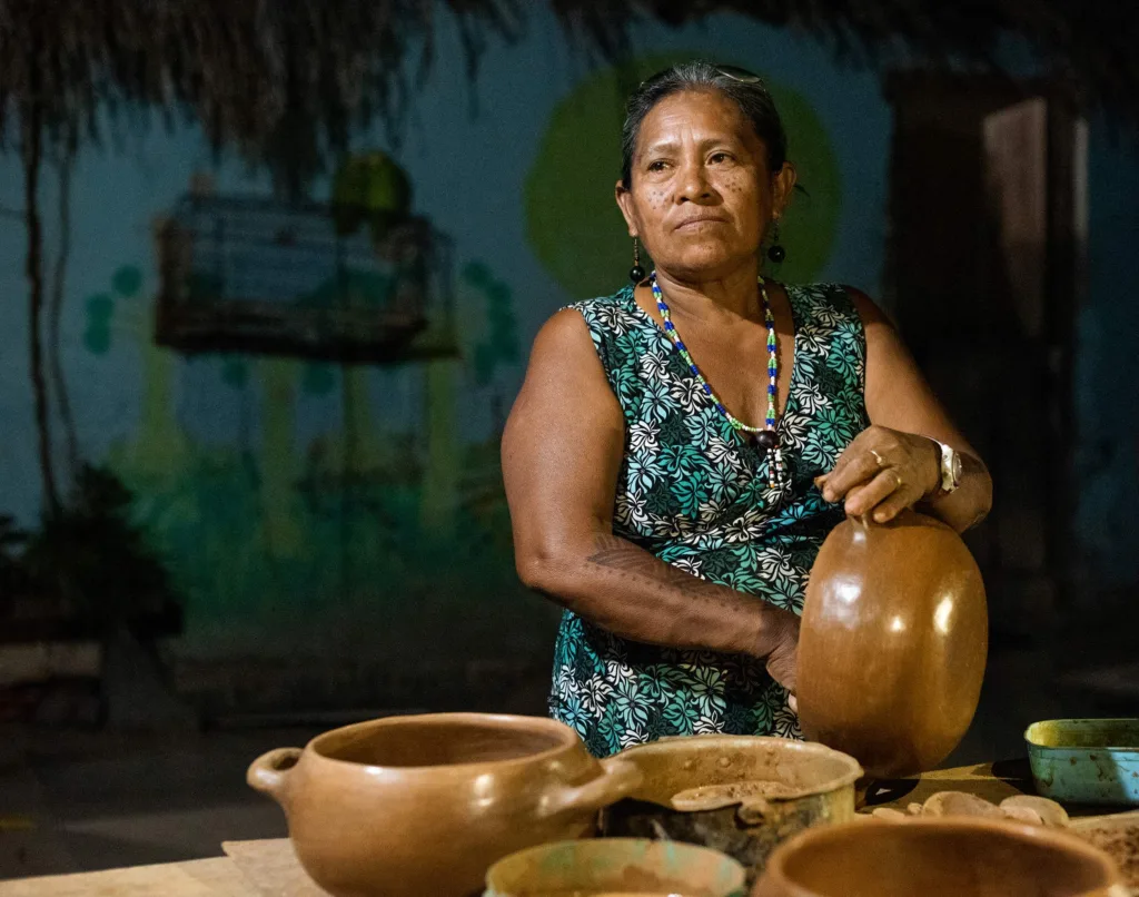 Artesã indígena modelando à mão uma panela de barro — Foto: Acervo Detur