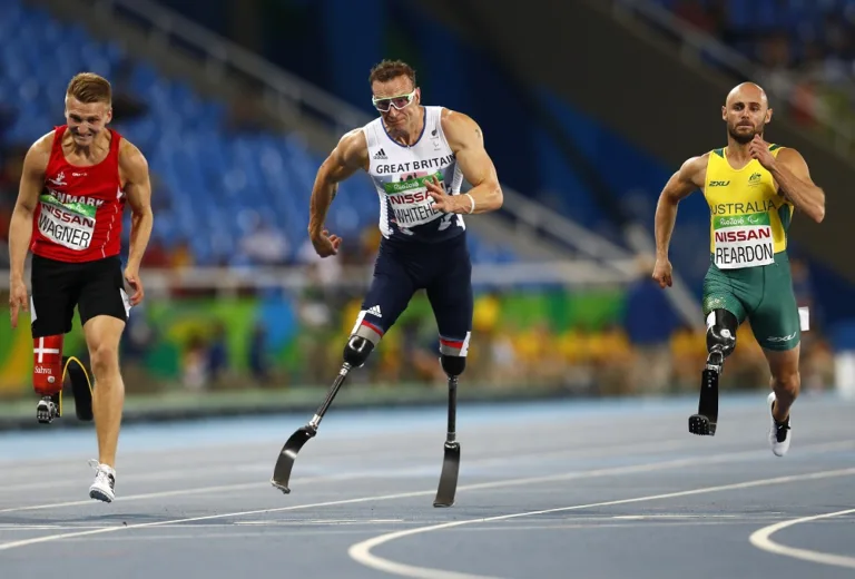 2016 Rio Paralympics - Athletics - Men's 100m - T42 Final - Olympic Stadium - Rio de Janeiro, Brazil - 15/09/2016. Scott Reardon of Australia (R) races to win the gold medal in the event as Richard Whitehead of Britain (C) and Daniel Wagner of Denmark (L) tie for the silver medal.  REUTERS/Jason Cairnduff   FOR EDITORIAL USE ONLY. NOT FOR SALE FOR MARKETING OR ADVERTISING CAMPAIGNS.