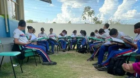 Alunos assistem aula fora das salas por conta do calor (Foto: Reprodução)