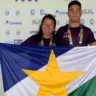 Professora Teca Marinho e atleta Kauã Santos posam com a bandeira de Roraima. (Crédito: Aquática Marinho)