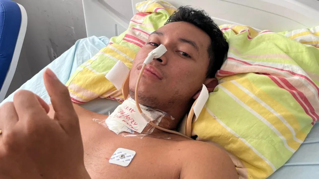 Devido à fratura cervical, Lukas está temporariamente se alimentando por sonda, pois sente dor ao sentar e ainda precisa permanecer deitado para evitar complicações. (Foto: Arquivo pessoal/Kendry Silva)