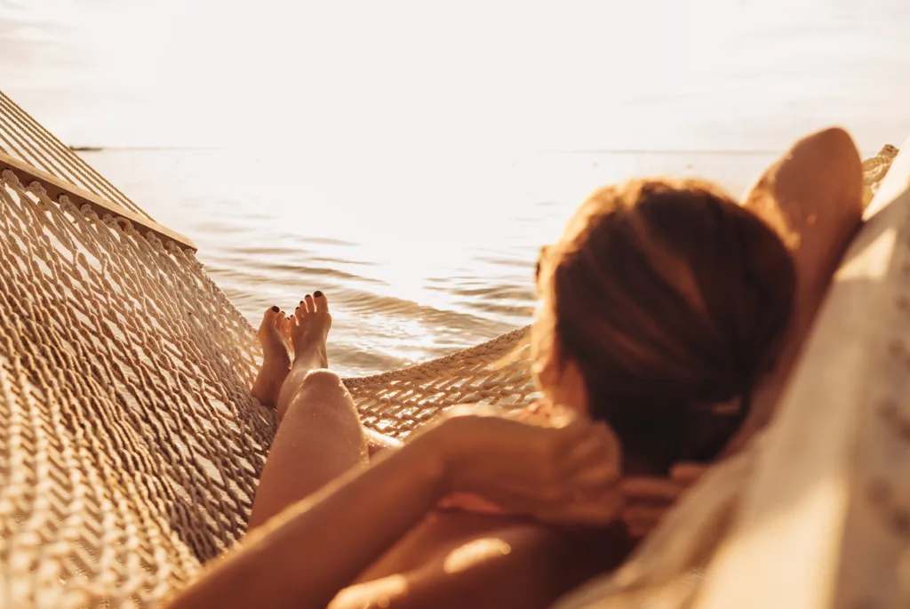 jovem mulher relaxando em frente ao por do sol