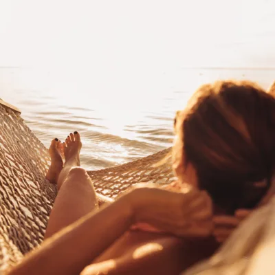 jovem mulher relaxando em frente ao por do sol