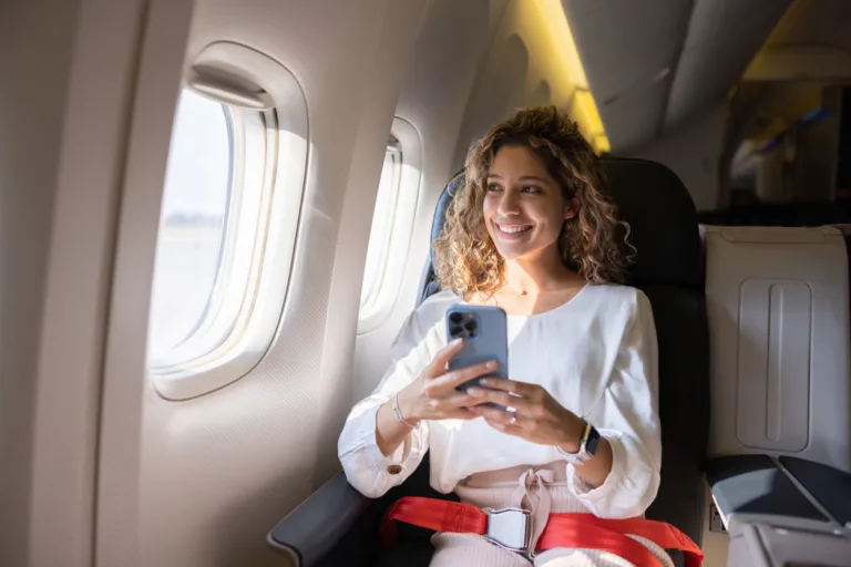 Female traveler using her cell phone in an airplane