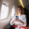 Female traveler using her cell phone in an airplane