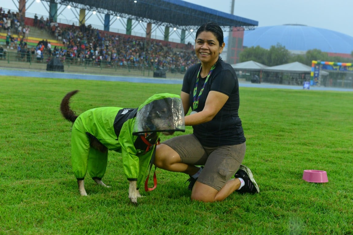 A tutora Lucimara Sampaio protegeu o vira-lata Theo com uma capa de chuva (Foto: Nilzete Franco/FolhaBV)