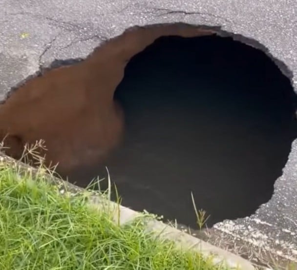 Parte do asfalto cedeu e deixou um buraco visível na lateral da rua Hitler de Lucena. (Foto: Reprodução)