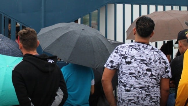 Venezuelanos se reúnem em frente ao prédio da Imigração na Rua Henry, em Porto de Espanha, aguardando a atualização de suas permissões de trabalho em maio de 2023 (Foto: Grevic Alvarado/Trinidad & Tobago Newsday)