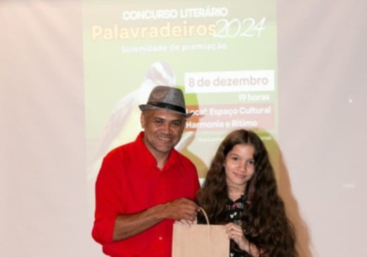 O integrante da Comissão Organizadora, Wilkinson Oliveira, com a aluna Laura Freire Mori, 1º lugar em 2024 na Categoria Ensino Fundamental I. Crédito da foto: Carla Wickert