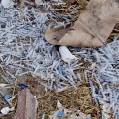 Seringas descartadas de forma irregular foram encontradas espalhadas no terreno baldio. (Foto: Wenderson Cabral)