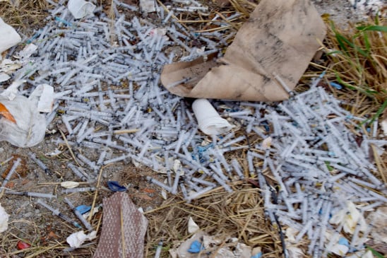 Seringas descartadas de forma irregular foram encontradas espalhadas no terreno baldio. (Foto: Wenderson Cabral)