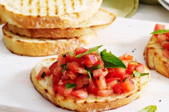 Torre levemente o pão, esfregue o alho, cubra com tomate temperado e finalize com azeite (Foto Divulgação)