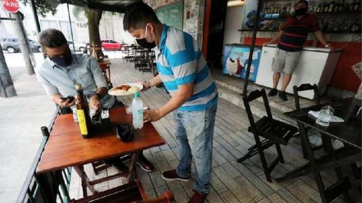 Em vários lugares, bares e restaurantes têm regras de distanciamento de mesas e número de clientes (Foto: Reuters)
