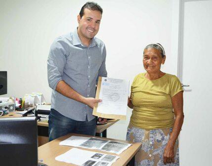 Dona Eugênia era só alegria ao receber o documento entregue pelo assessor jurídico (Foto: Divulgação)