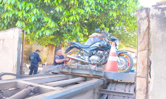 Uma das motos sendo recolhida da casa, localizada na Rua Mestre Albano (Foto: Diane Sampaio)