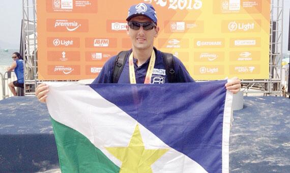 O nadador roraimense exibe a bandeira do Estado no local da premiação da competição (Foto: Divulgação)