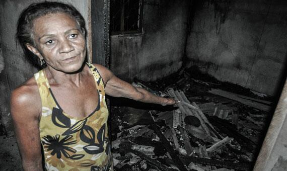 Rosimar de Araújo mostra as cinzas que sobraram de sua casa e pede ajuda para recomeçar a vida (Foto: Rodrigo Sales)