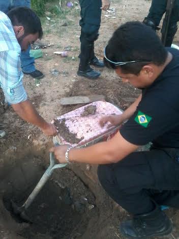 Momento em que agentes e PMs desenterram parte dos 40 litros de cachaça artesanal