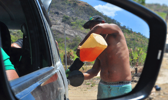 Indígena abastecendo carro com gasolina venezuelana no domingo pela manhã, na Vila do Surumu (Fotos: Rodrigo Sales)