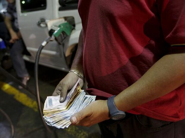 Homem no posto de gasolina em Caracas (Foto: Fernando Llano)