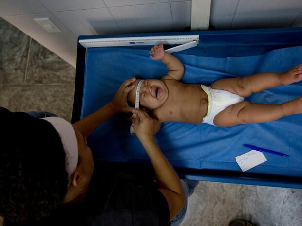 Bebê tem a cabeça medida durante exame de rotina em Caracas (Foto: Fernando Llano)