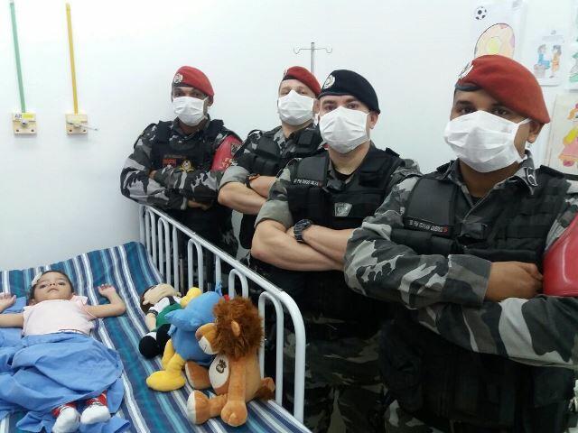 Os integrantes do Bope com a criança doente (Divulgação)