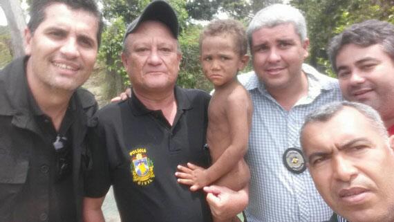 Garoto Davi Francisco nos braços do policial que o encontrou ontem pela manhã (Foto: Divulgação)
