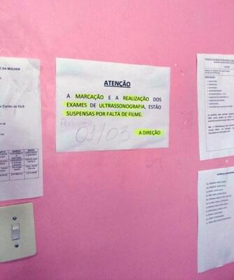 Cartaz fixado informa a falta de material para atender à população (Foto: Divulgação)