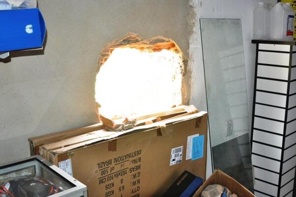 Criminosos fizeram buraco na parede para retirar os produtos (Foto: Wenderson de Jesus/Folha BV)
