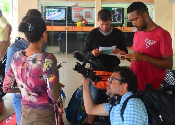 Dado Galvão registrando momento em que imigrantes receberam cartas, ano passado, na rodoviária de Boa Vista (Foto: Divulgação)
