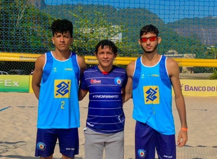 Dupla Evandro e David com o técnico Wallace Souza - os três foram campeões mundiais Sub-16 em 2019 (Foto: Divulgação)