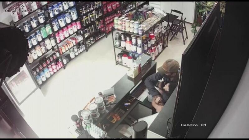 Momento em que o bandido imobiliza a atendente (Foto: Reprodução)