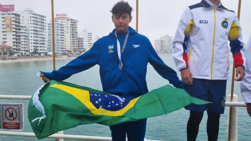Joan Penaloza sobe ao pódio com a bandeira brasileira (Foto: Divulgação)