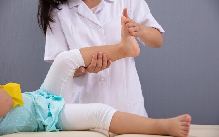 Criança com distrofia muscular em atendimento com fisioterapeuta