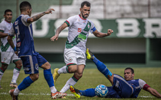 O volante Belão, do São Raimundo, tenta impedir avanço de jogador da Tuna Luso
